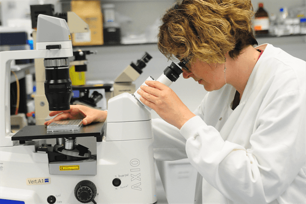 Professor Silvia Marino looking down a microscope