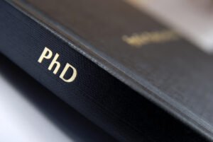 Black book with the letters PhD along the spine